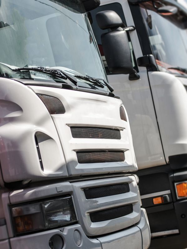Close-up of white truck fronts parked side by side.