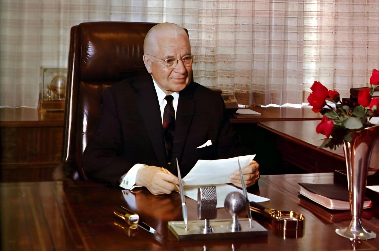 Herbert W Armstrong, Pastor General of the Worldwide Church of God sits at his desk.