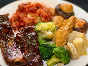 Plate with ribs, broccoli, mushrooms, and kimchi.
