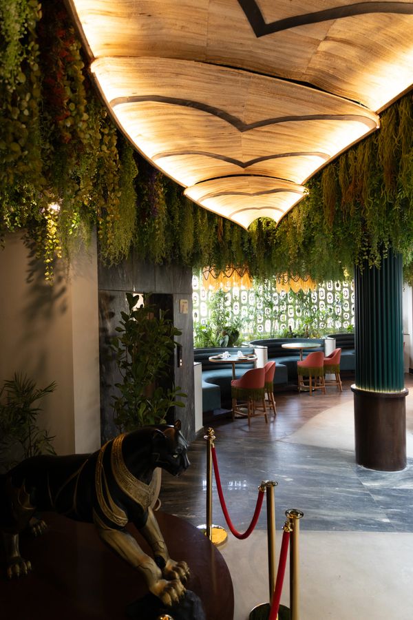 Elegant dining area with lush greenery and unique ceiling lights.
