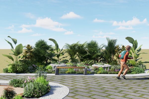 A man walking near a lush garden with a bench and palm trees.