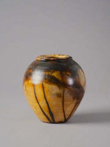Handcrafted ceramic pot with smoky, earthy tones and natural patterns.