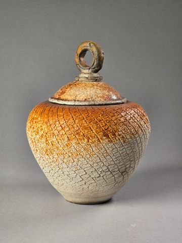 Rustic ceramic jar with a textured, gradient finish and a looped handle lid.