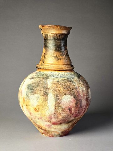 Antique ceramic vase with a textured, multicolored surface.