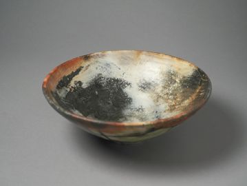 A rustic ceramic bowl with a smoky, textured finish.