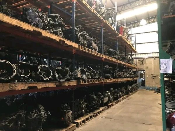 Warehouse shelves filled with various automotive engines and parts.