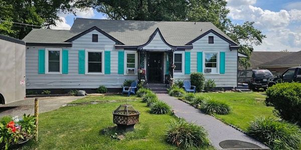 Charming white house with turquoise shutters and a neat front garden.