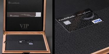 Elegant black VIP Visa credit card in a luxurious wooden box.