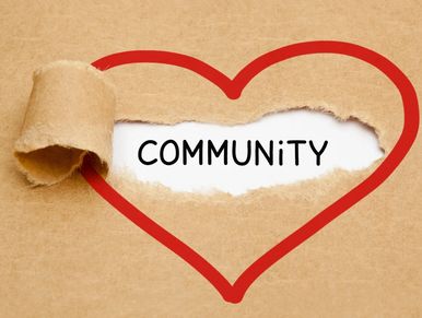 Torn paper reveals the word COMMUNITY inside a red heart outline.
