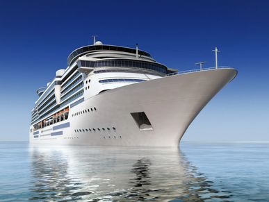 A large white cruise ship sailing on calm waters under a clear blue sky.