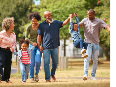 Happy family enjoying a sunny day outdoors, holding hands and playing together.
