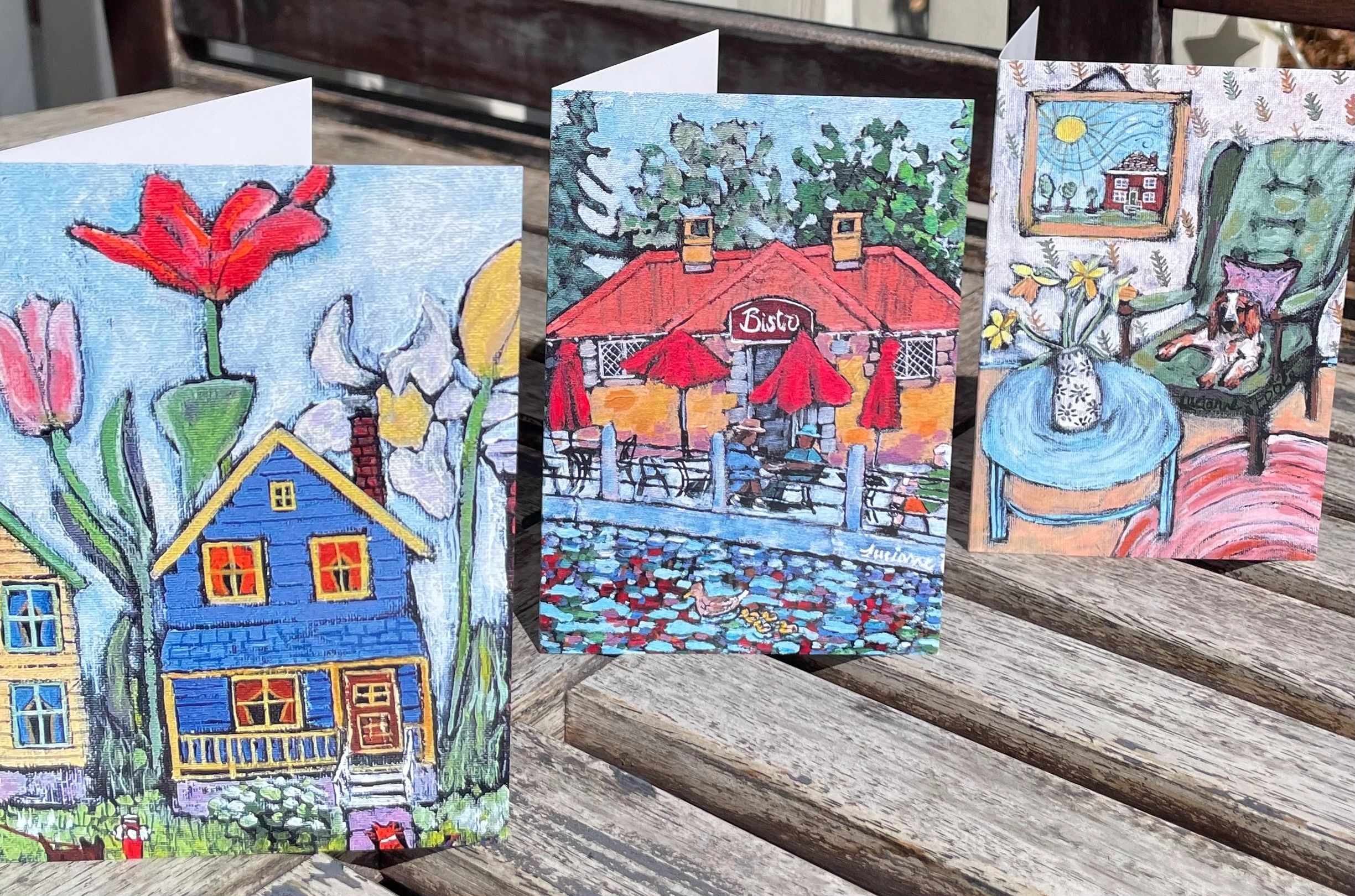 A photo of three greeting cards featuring spring and summer scenes.