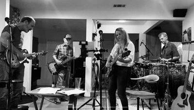 Black and white photo of a band rehearsing indoors.