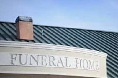 Front view of a funeral home building under a clear sky.