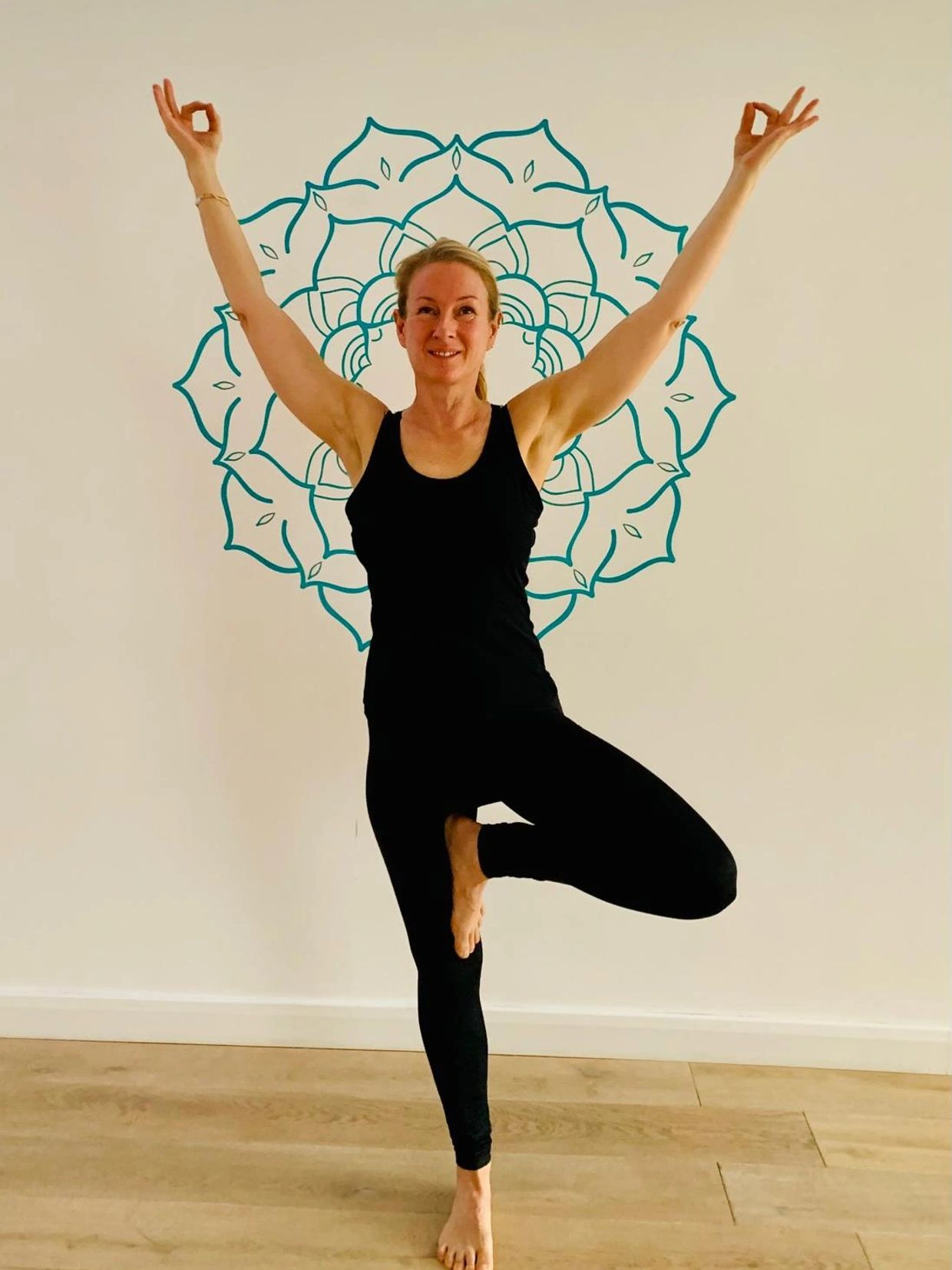 Woman practicing yoga in tree pose.