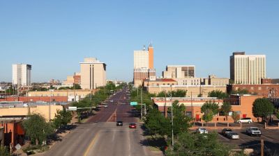 City street leading to downtown with tall buildings.