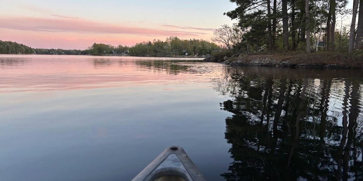 Canoe on a calm Georgian Bay shoreline at sunset, reflecting the peaceful, grounded approach of psyc