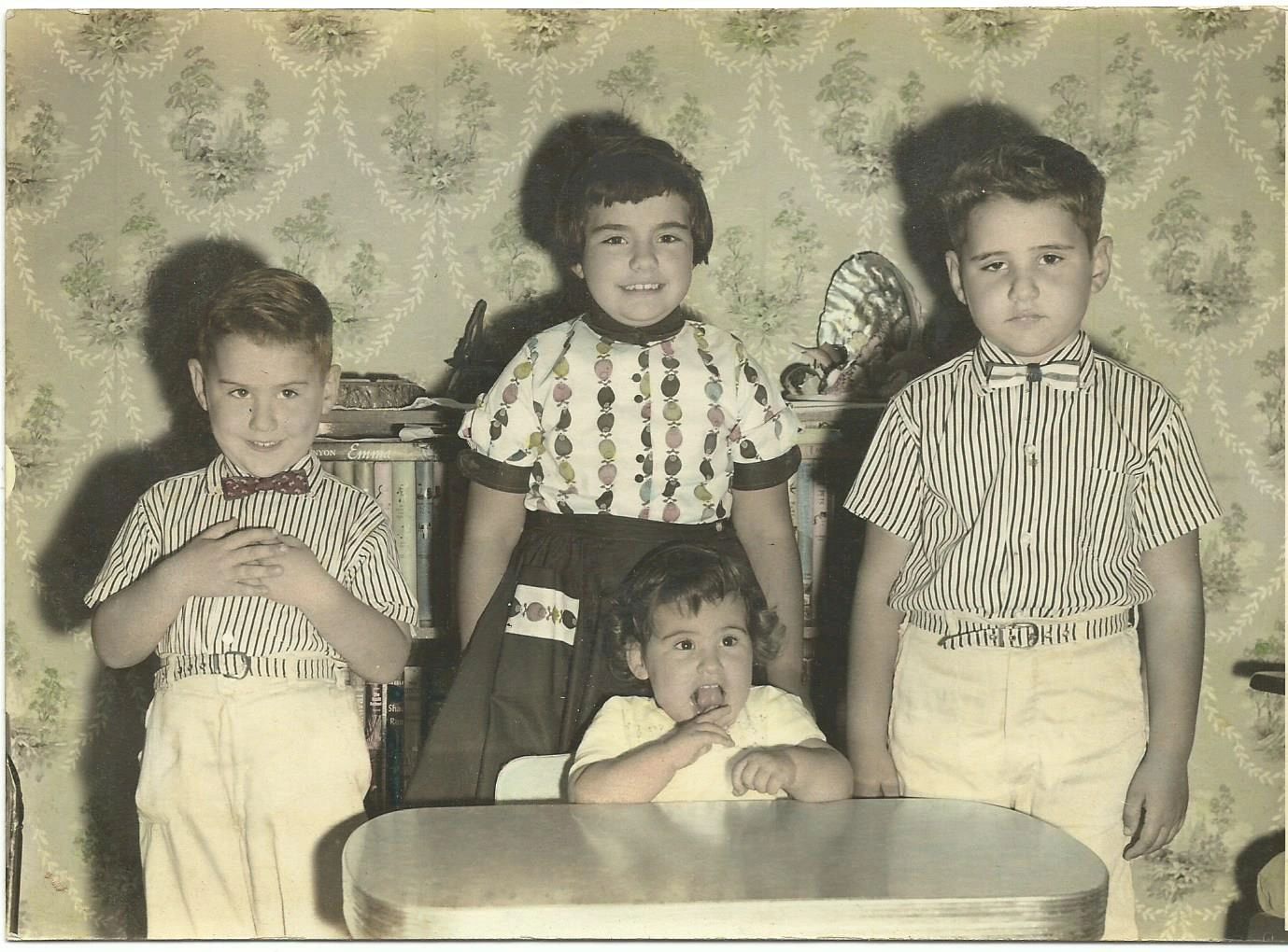 The author and his siblings. The author is the one who is not smiling. 