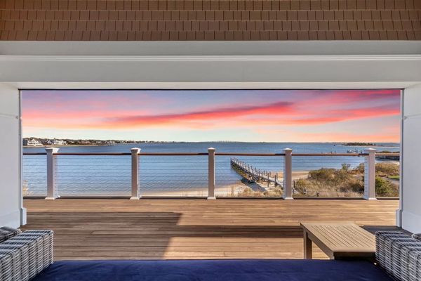 Scenic waterfront view from a cozy deck at sunset.