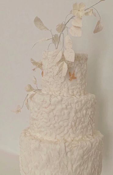 Bas relief cake with gold accents and white sugar flowers