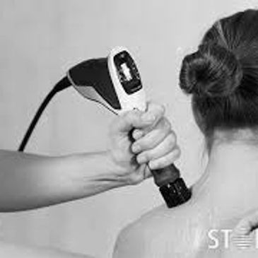 Chiropractor performing Shockwave therapy to a patient's shoulder.