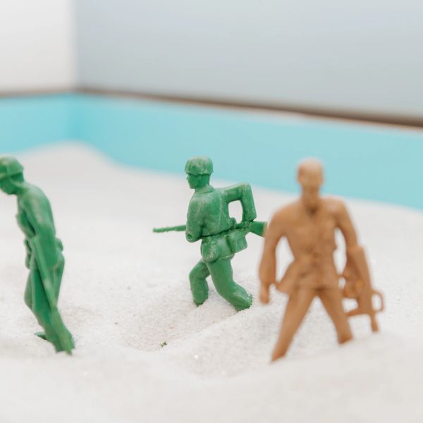Toy soldiers positioned in white sand.