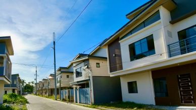 Modern residential neighborhood with rows of houses under a clear sky.