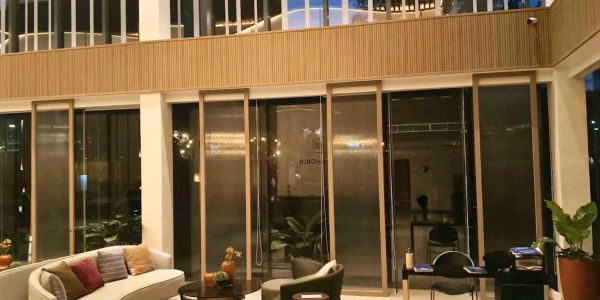 Modern indoor seating area with large glass windows and warm lighting.