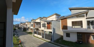 Modern suburban houses lined up along a sunny street.