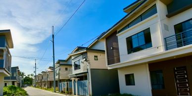 Modern suburban houses lined up under a clear blue sky.