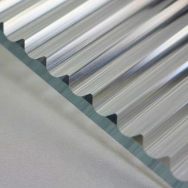 Close-up of transparent corrugated plastic sheet showing its wavy pattern.