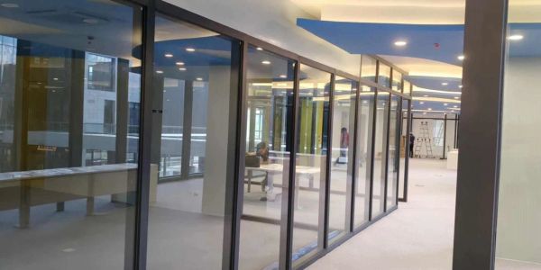 Modern office corridor with glass walls and minimalistic design.