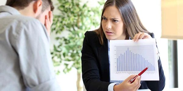 Woman showing a chart to a stressed man.