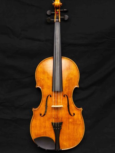 A classic wooden violin against a black background.