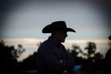 Silhouette of a man wearing a cowboy hat at dusk.