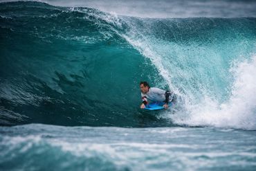 Surfer skillfully riding inside a powerful ocean wave.