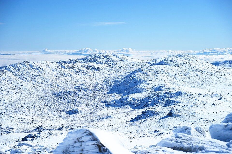 Snow-covered mountain range under a clear blue sky.