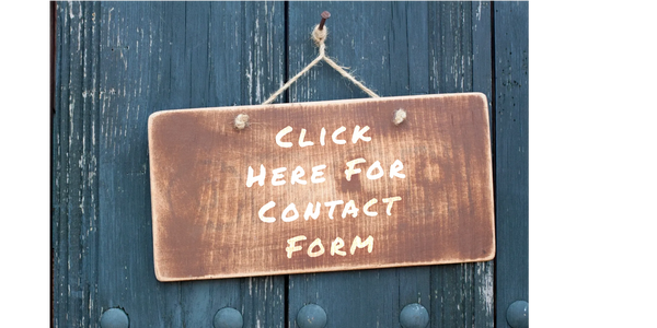 Nailed wooden sign hung with string on blue fence-like wood.