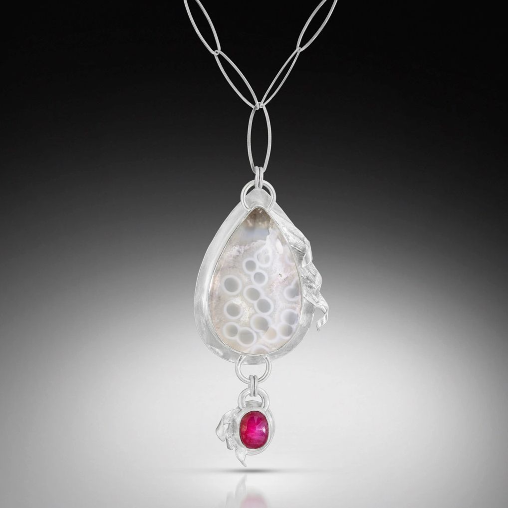 Elegant pendant with a teardrop agate and a small ruby, set in silver.