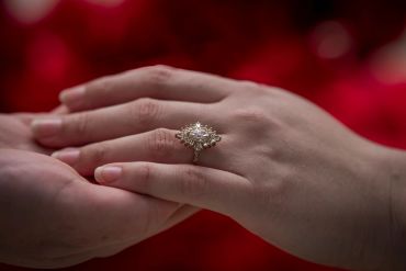 A close-up of a hand with a sparkling engagement ring.