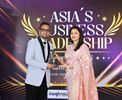 Man in white tuxedo and woman in pink gown at Asia's Business Leadership Awards.