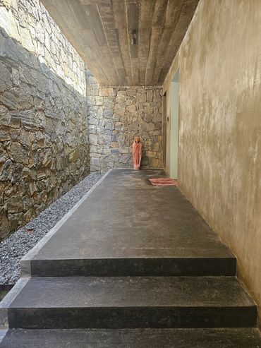Person standing at the end of a stone corridor.