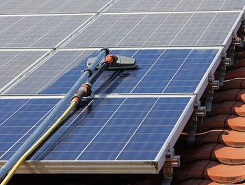 Robot cleaning solar panels on a roof.