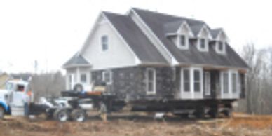 A two-story house under construction with stone and siding exterior.