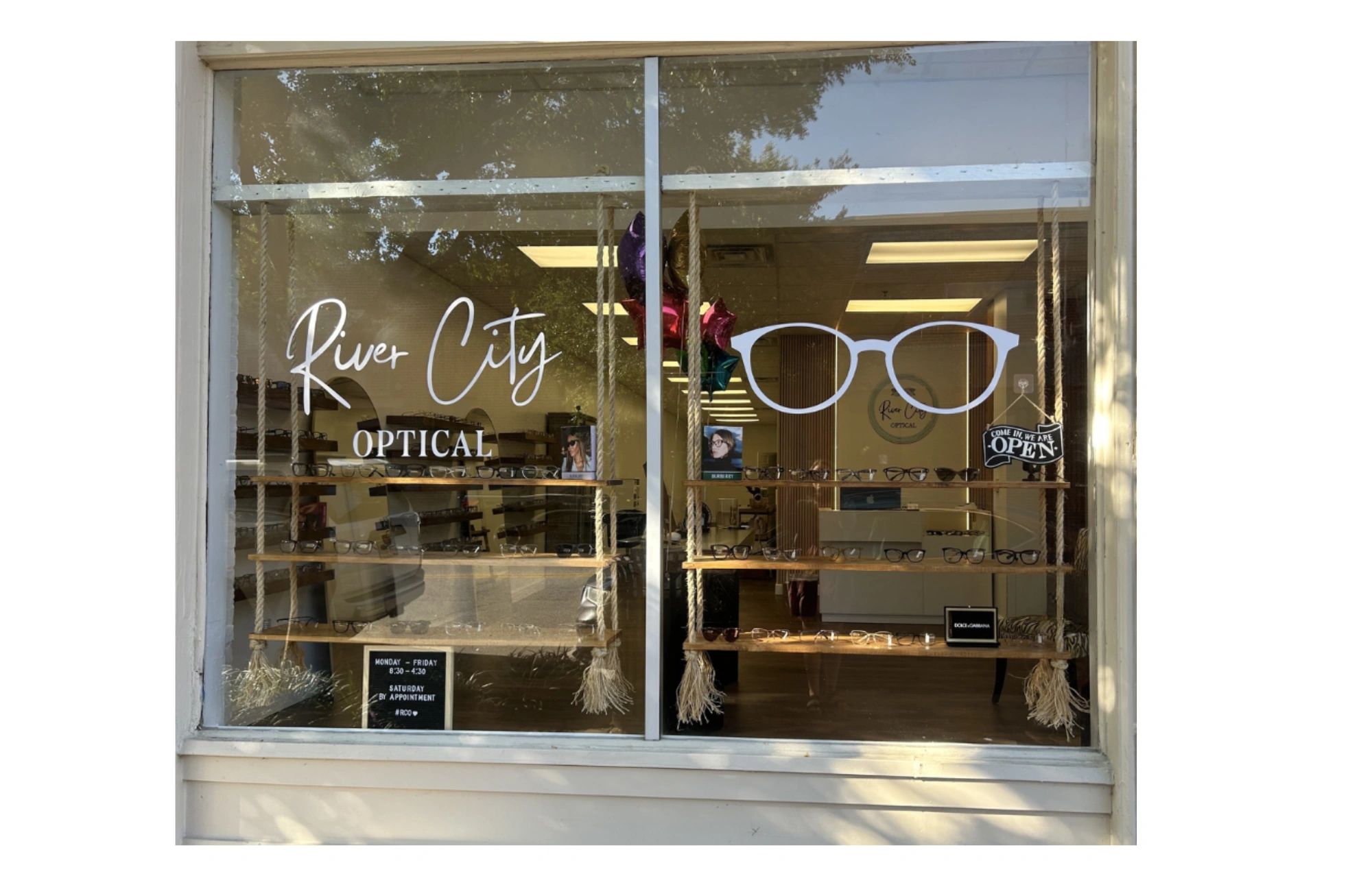 Storefront of River City Optical with glasses display.