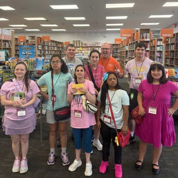 Group of eight people posing in a bookstore.