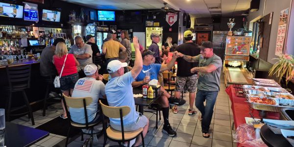 People enjoying a lively gathering at a bar with food and drinks.