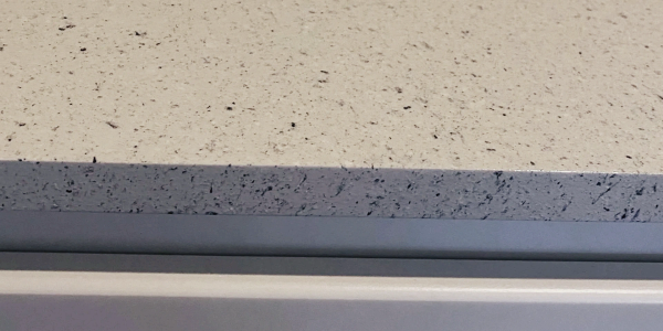 Close-up detail of a durable, polished stone-look refinished countertop edge applied during a one-da