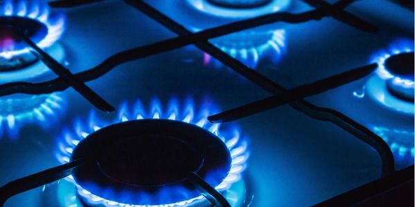 4 gas rings burning blue on hob in kitchen