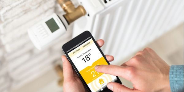 Person adjusting central heating temperature using a mobile app